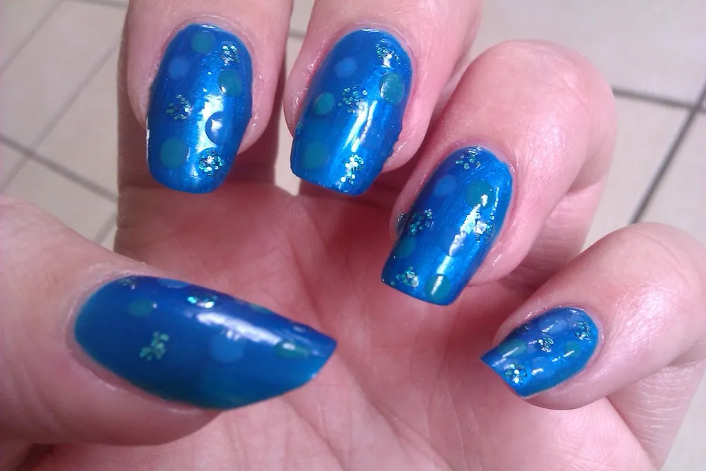 Uñas con esmalte jelly azul cobalto y puntos claros