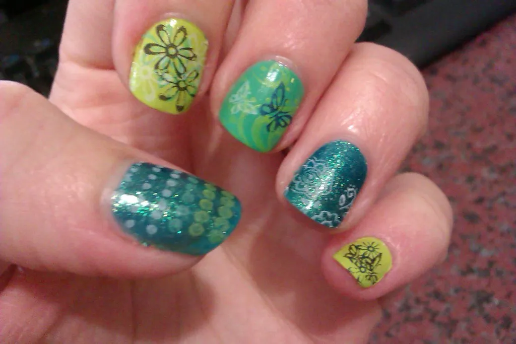 Uñas en verdes y lima con stamping de flores y glitter